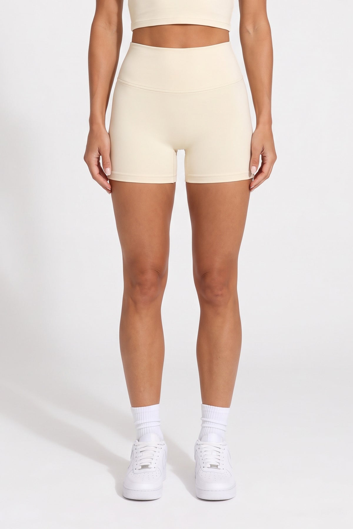 Front view of buttercream organic cotton high-waisted shorts with a matching halter top.