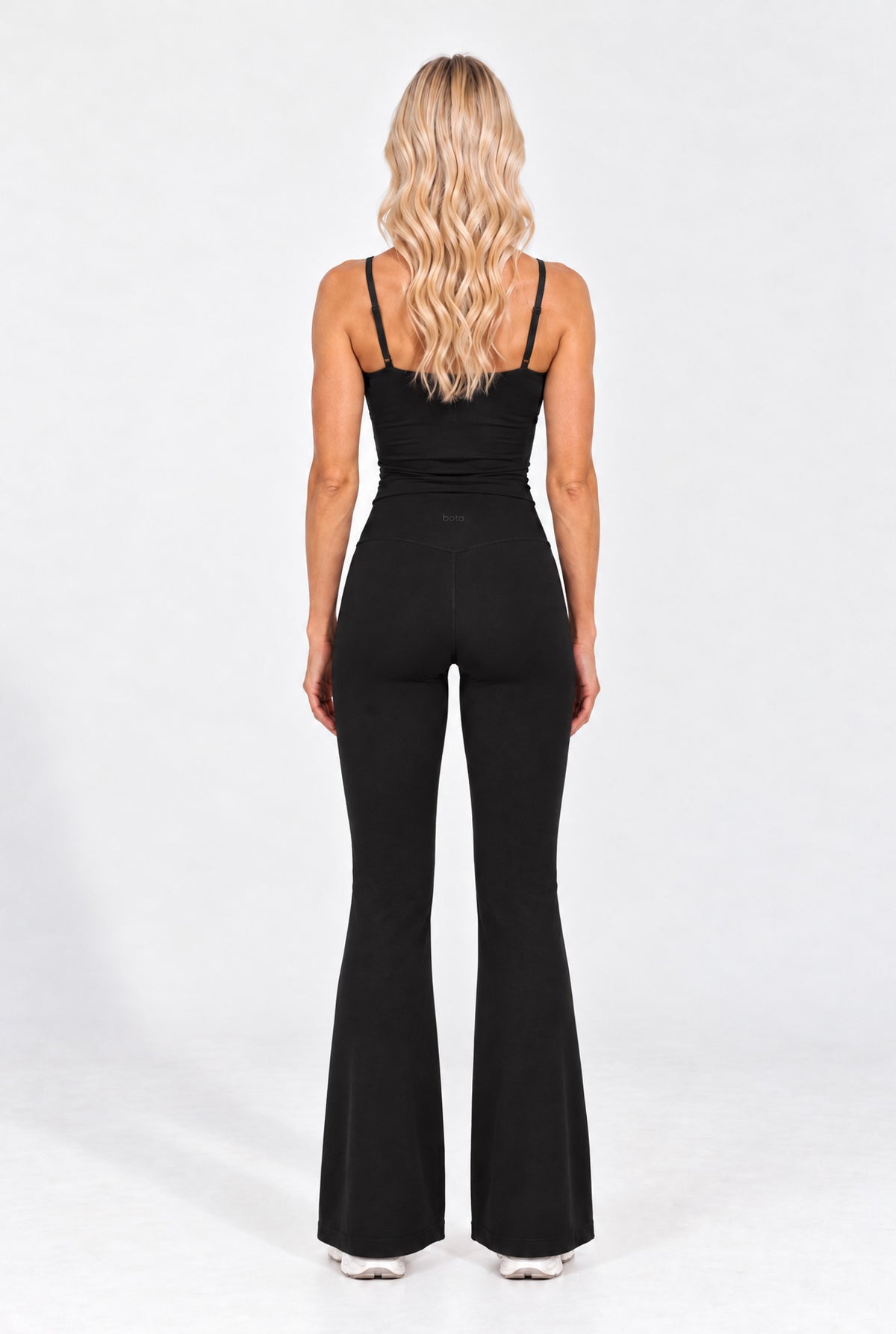Back view of a black organic cotton cami top with flare leggings.