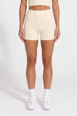 Front view of buttercream organic cotton high-waisted shorts with a matching halter top.
