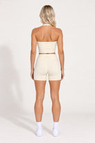 Back view of buttercream organic cotton high-waisted shorts with a matching halter top.