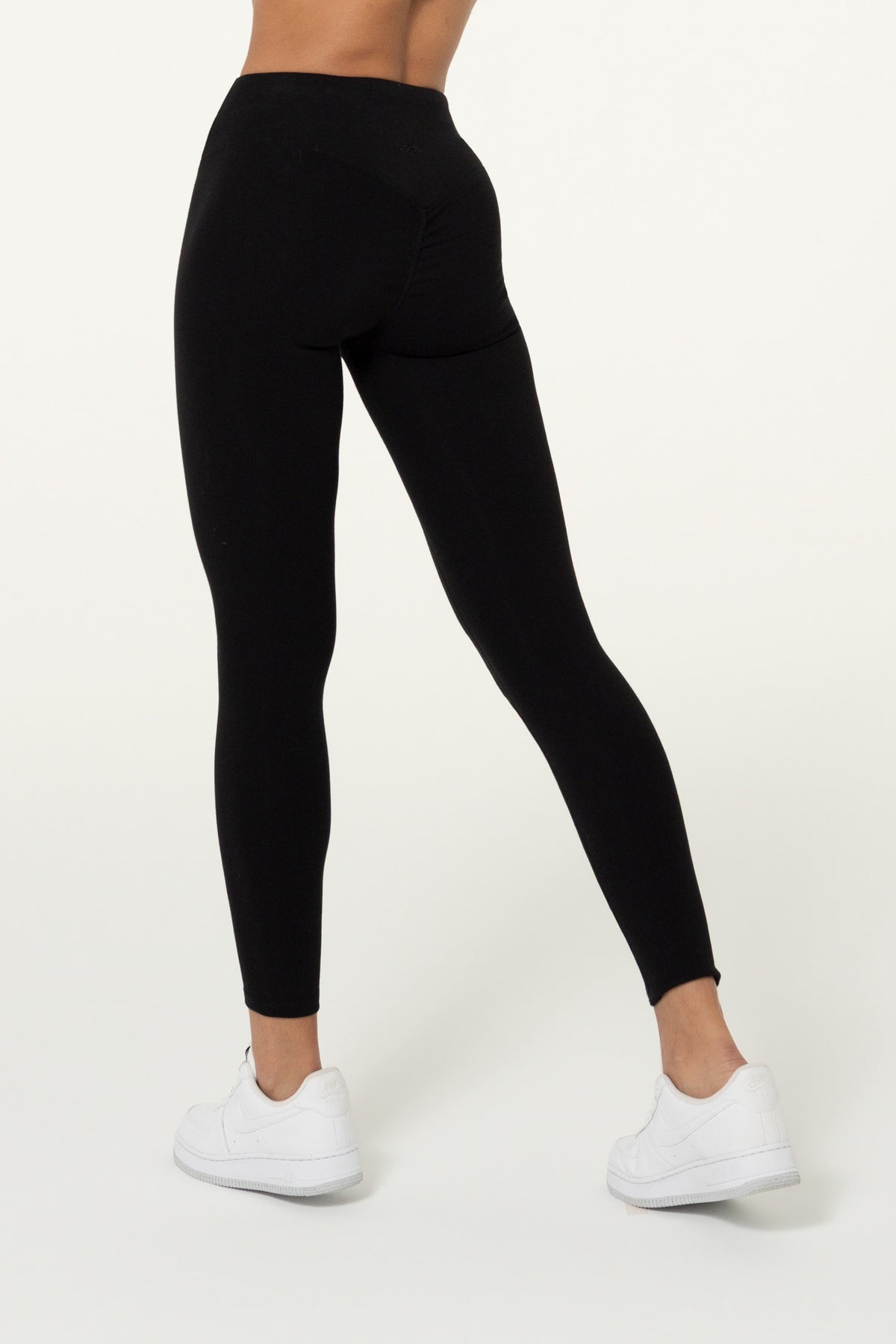 Back view of black organic cotton full-length leggings with a matching top.