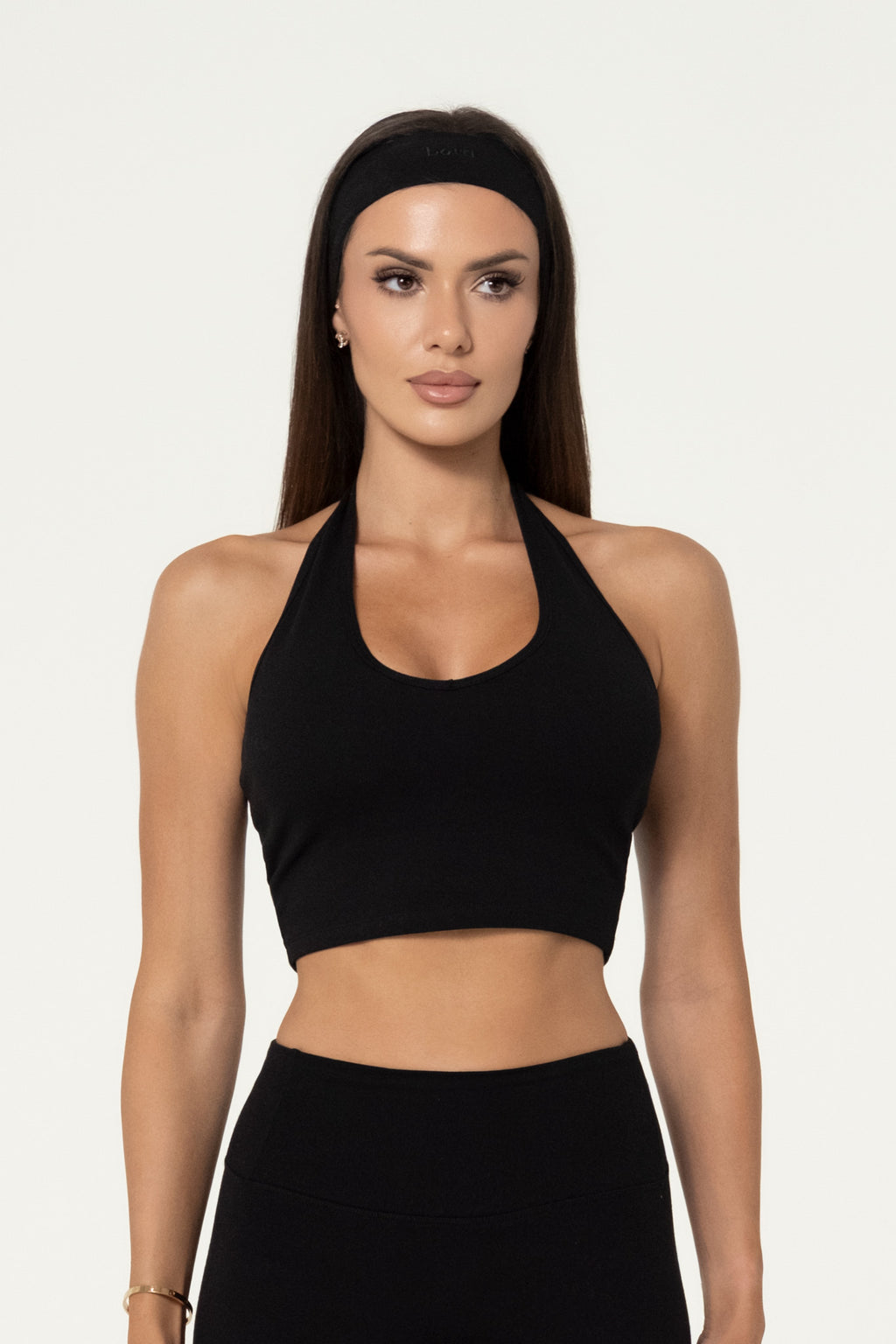 Woman wearing a black organic cotton halter top with matching leggings.