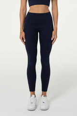 Model wearing navy organic cotton high-waisted leggings and matching halter top.