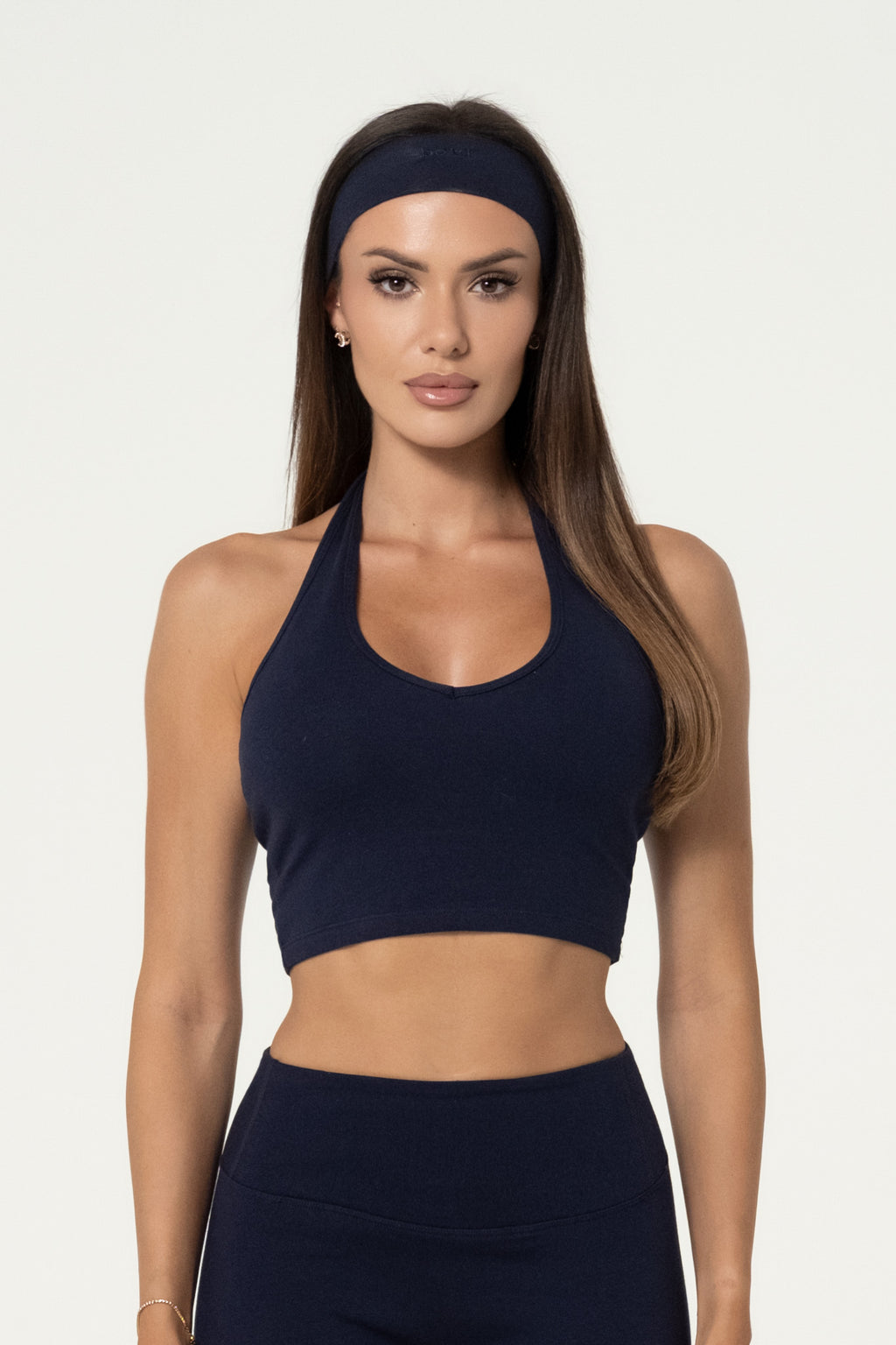 Woman wearing a navy organic cotton halter top with matching high-waisted leggings.