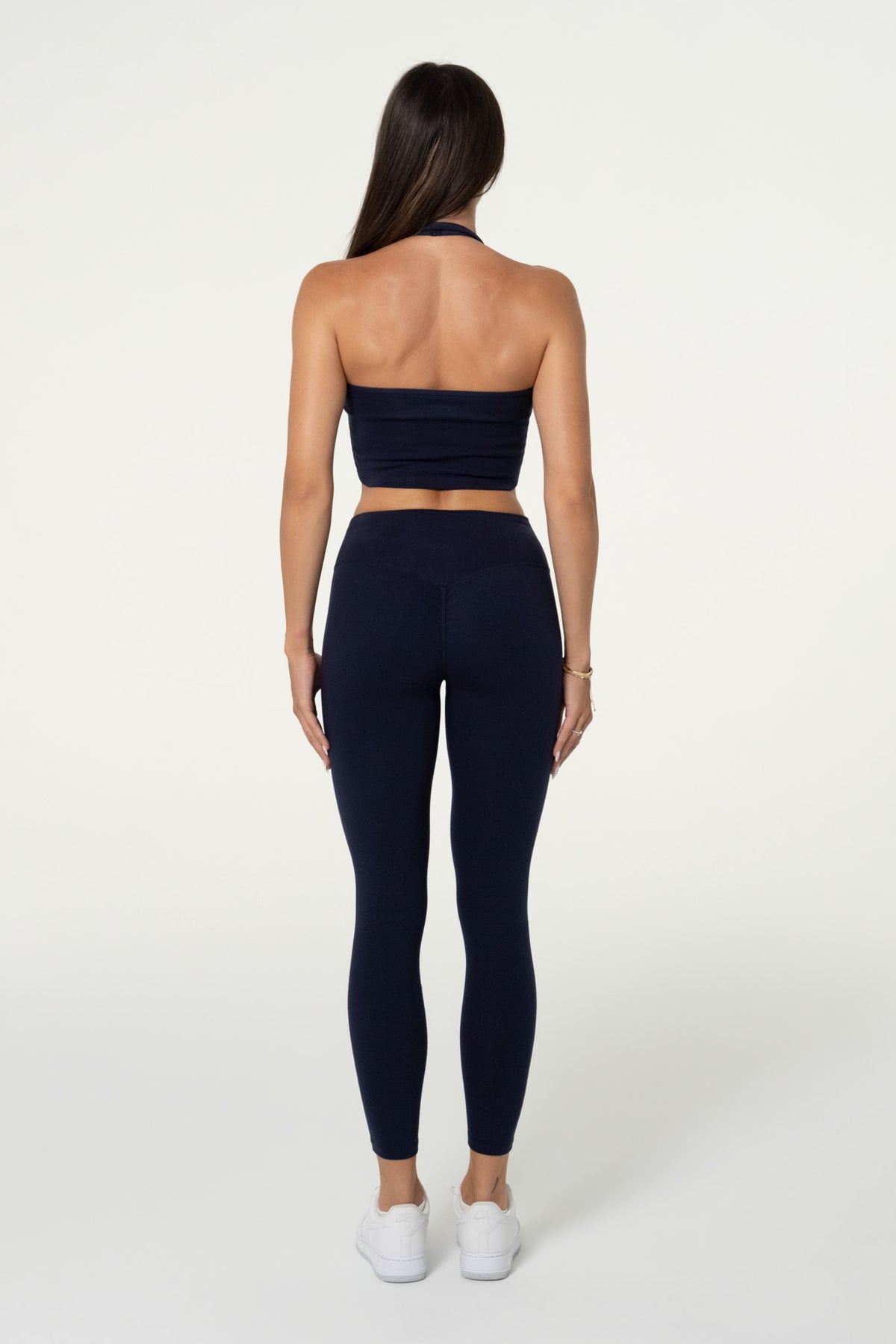 Back view of navy organic cotton high-waisted leggings and halter top.