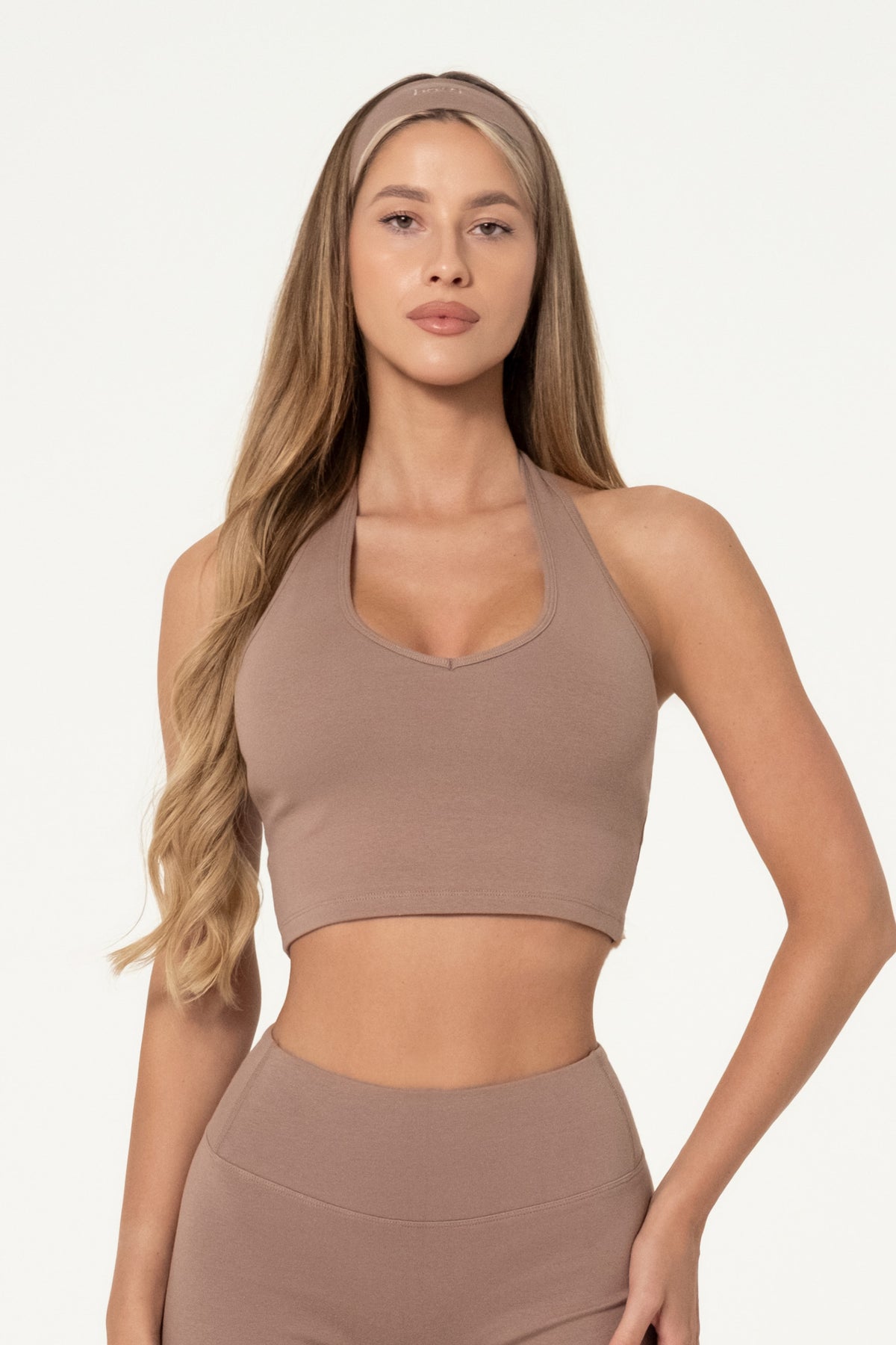 Woman wearing a truffle brown organic cotton halter top with matching high-waisted shorts.