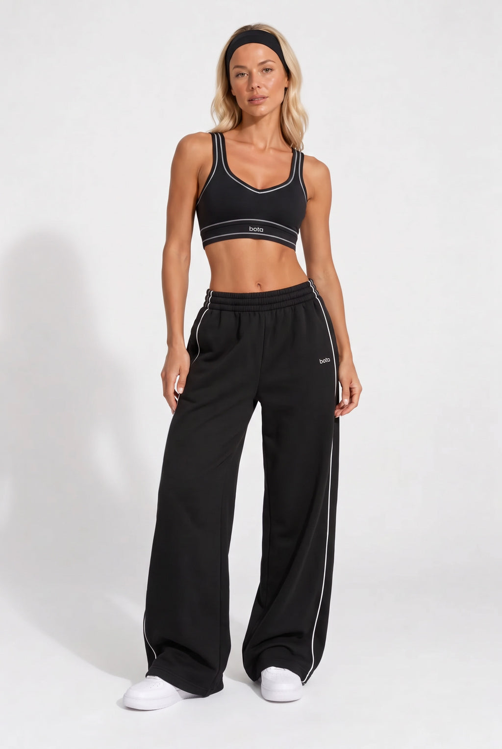 Black organic cotton sports bra and matching sweatpants, full-length view.