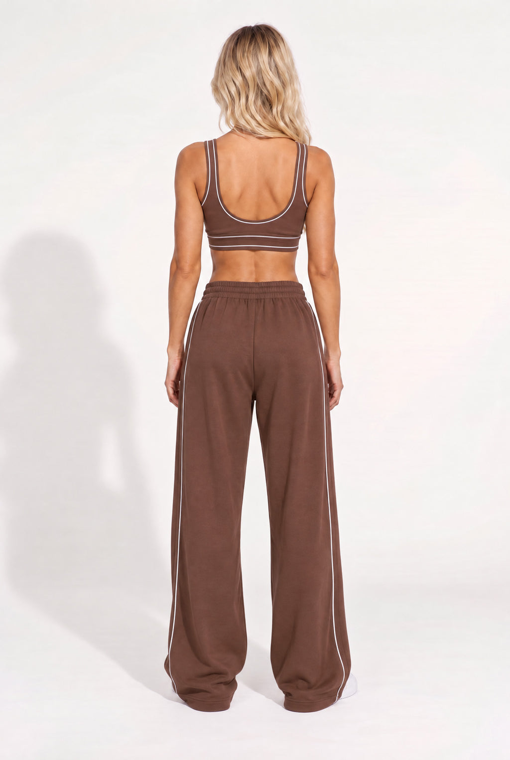 Back view of a chestnut brown organic cotton sports bra and oversized sweatpants.