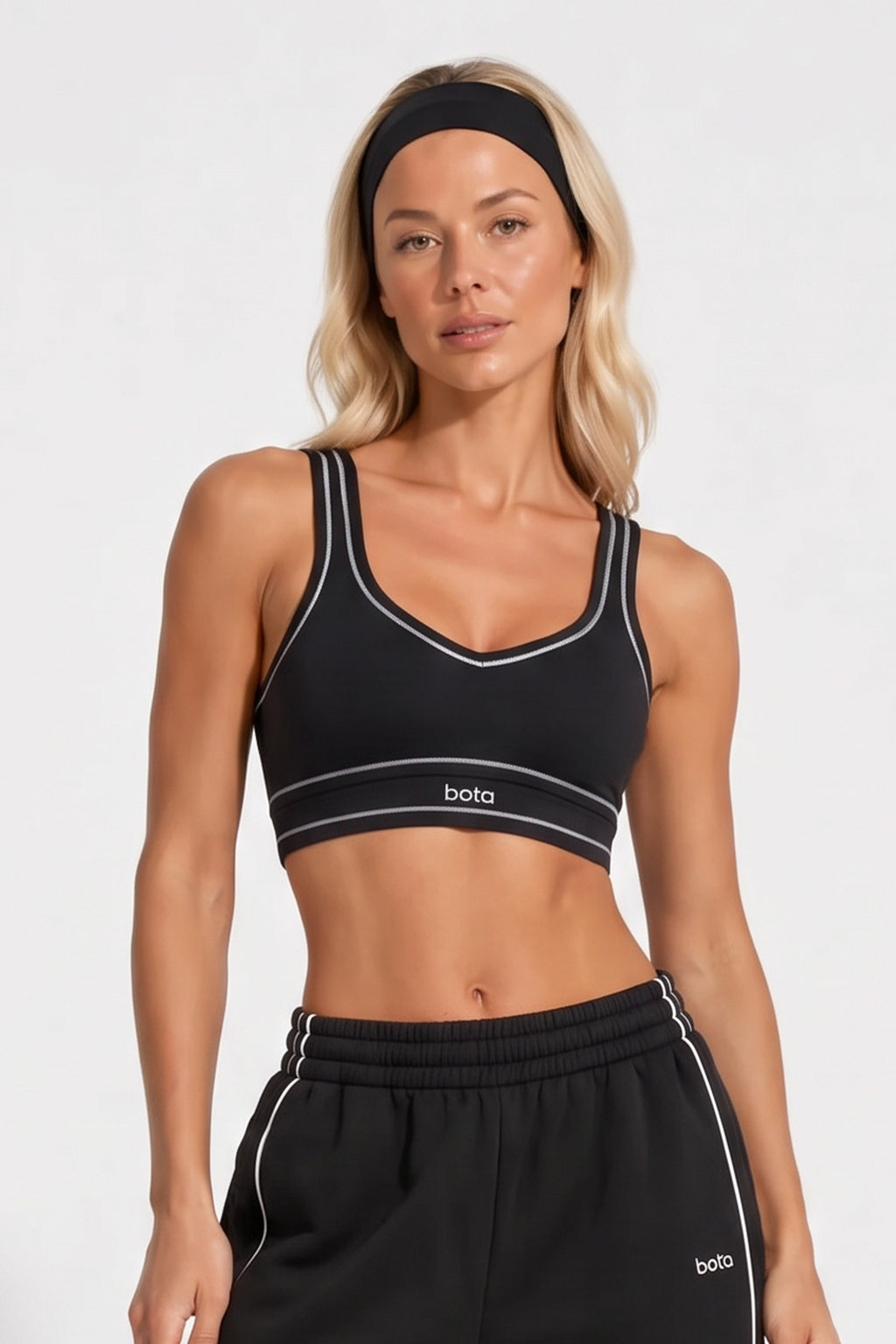 Black organic cotton sports bra with a subtle v-neckline and matching sweatpants.