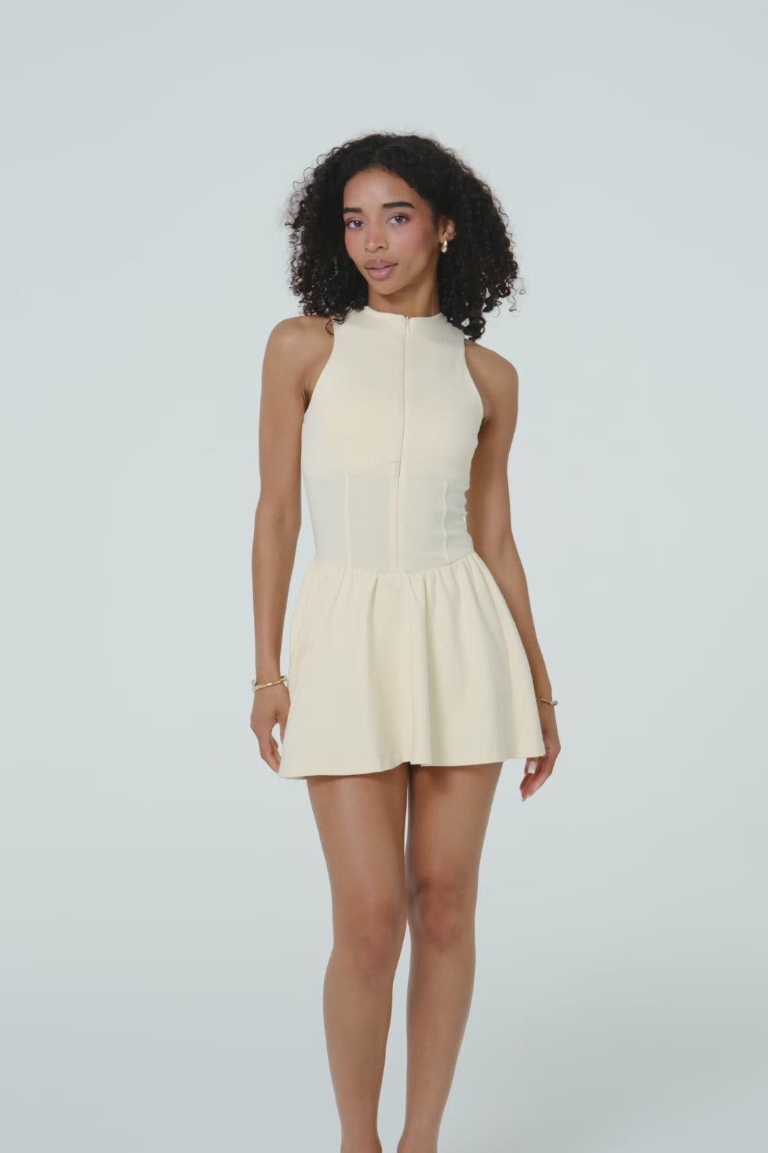 Model moving in a buttercream organic cotton tennis dress.
